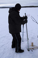 Sawing a hole in the ice to retrieve the net